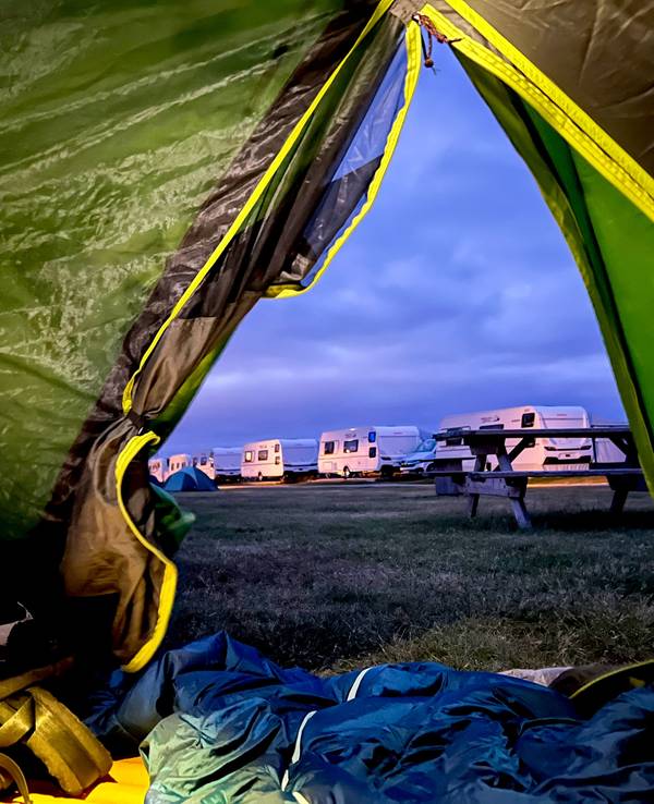 Blick aus einem Zelt auf einen Campingplatz.