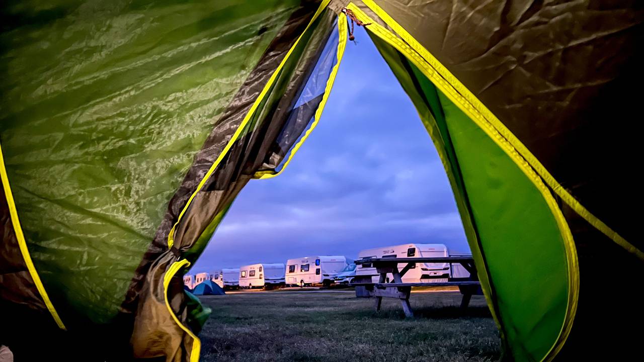 Blick aus einem Zelt auf einen Campingplatz.