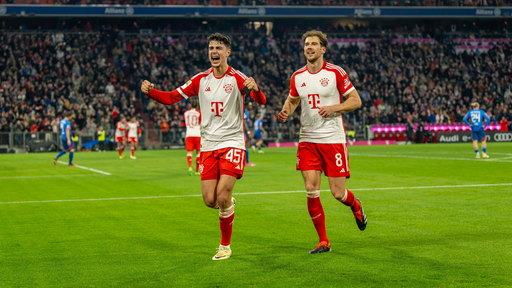 Aleksandar Pavlovic und Leon Goretzka jubeln gemeinsam über ein Tor für den FC Bayern.