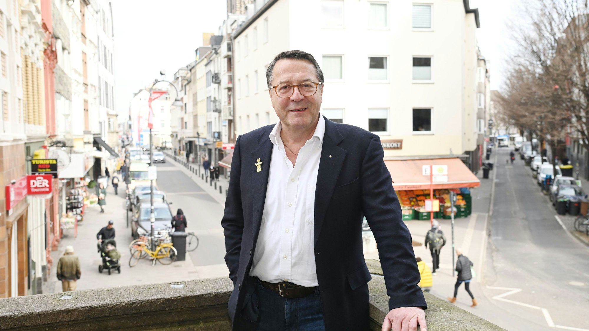 Hans Mörtter steht auf einem Balkon in Köln und schaut in die Kamera.