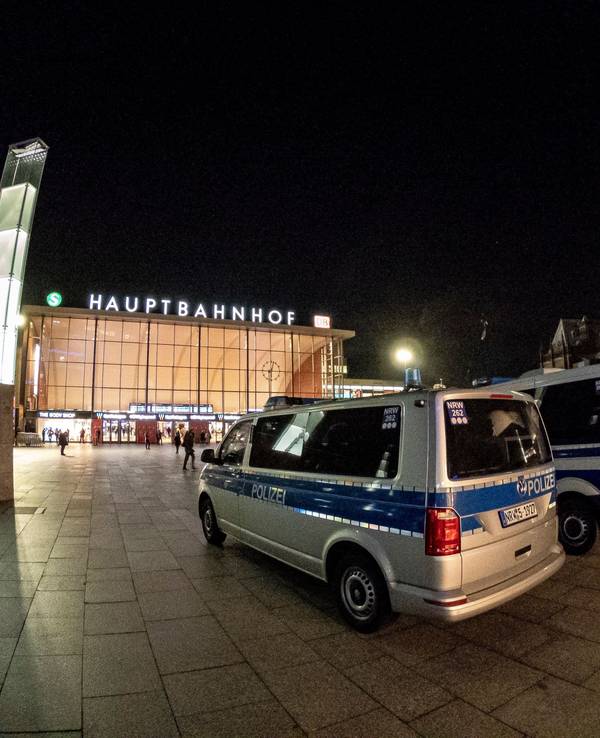 Polizeiwagen stehen vor dem Kölner Hauptbahnhof bei Nacht.