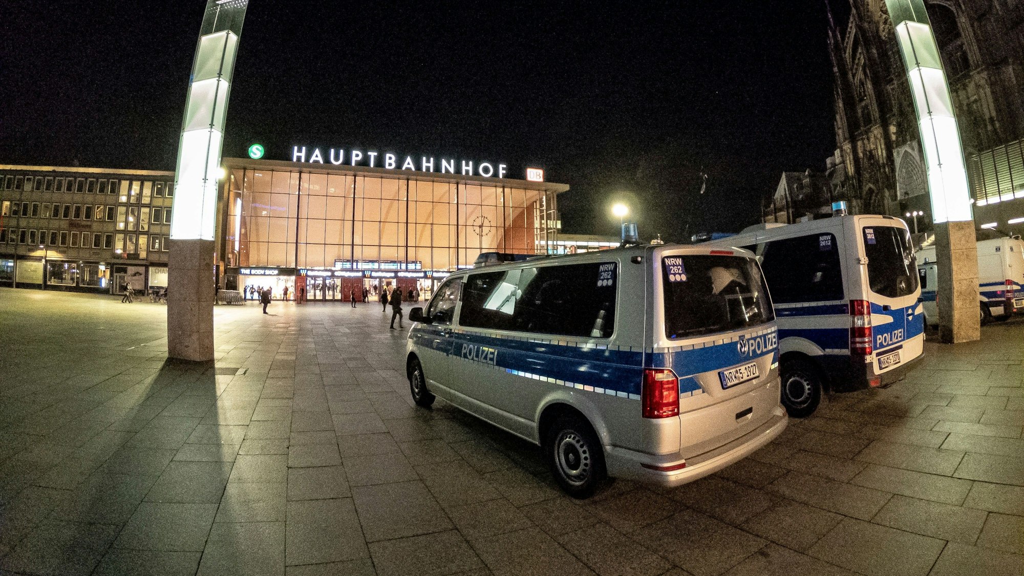 Polizeiwagen stehen vor dem Kölner Hauptbahnhof bei Nacht.