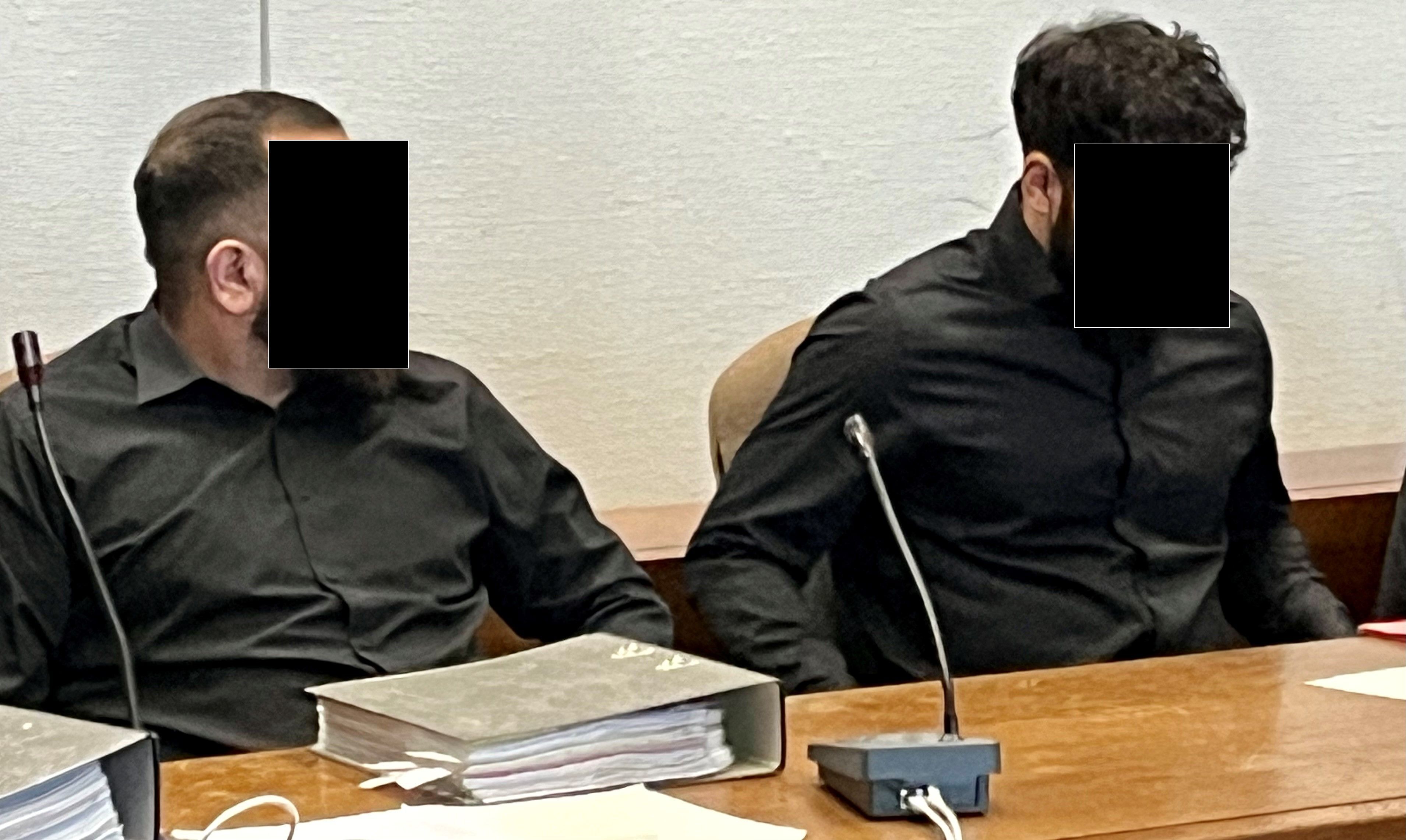 Zwei junge Männer sitzen nebeneinander auf der Anklagebank.