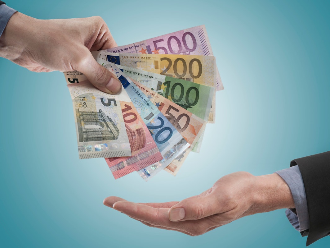 Ein Chef bei der Übergabe von Gehalt an einen Mitarbeiter.