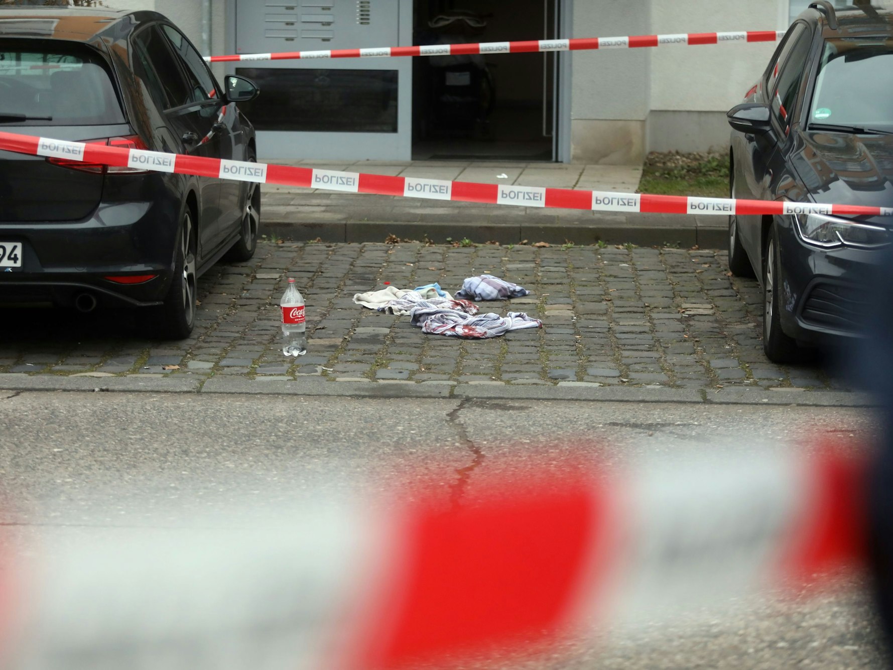 Auf einem Parkplatz liegen blutige Tücher, der Bereich ist mit Polizei-Flatterband abgesperrt.