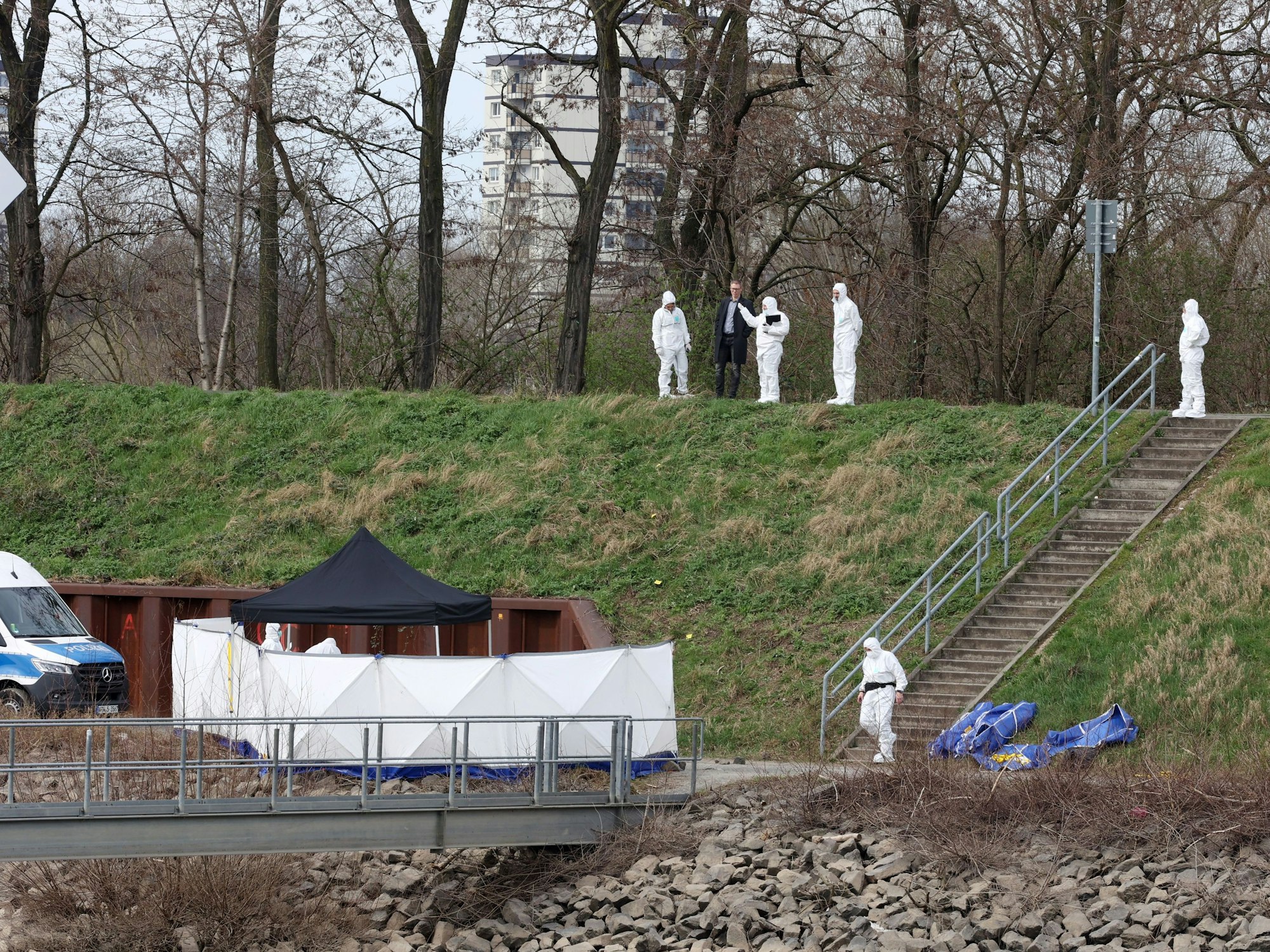 Kräfte der Spurensicherung sind in Schutzanzügen am Tatort.