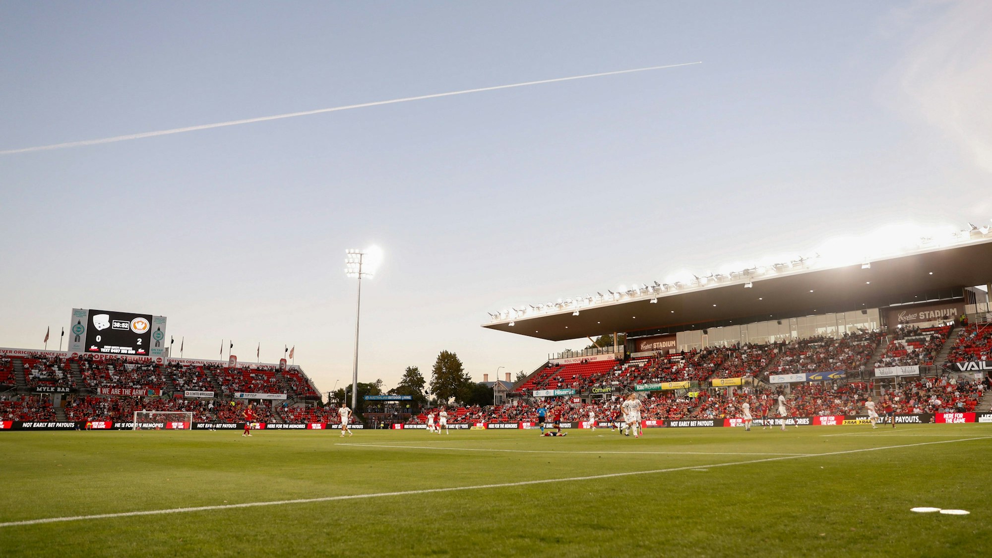 Fußball-Profis von Adelaide United und Western Sydney Wanderers laufen über das Spielfeld. Im Hintergrund sind die Tribünen zu sehen.