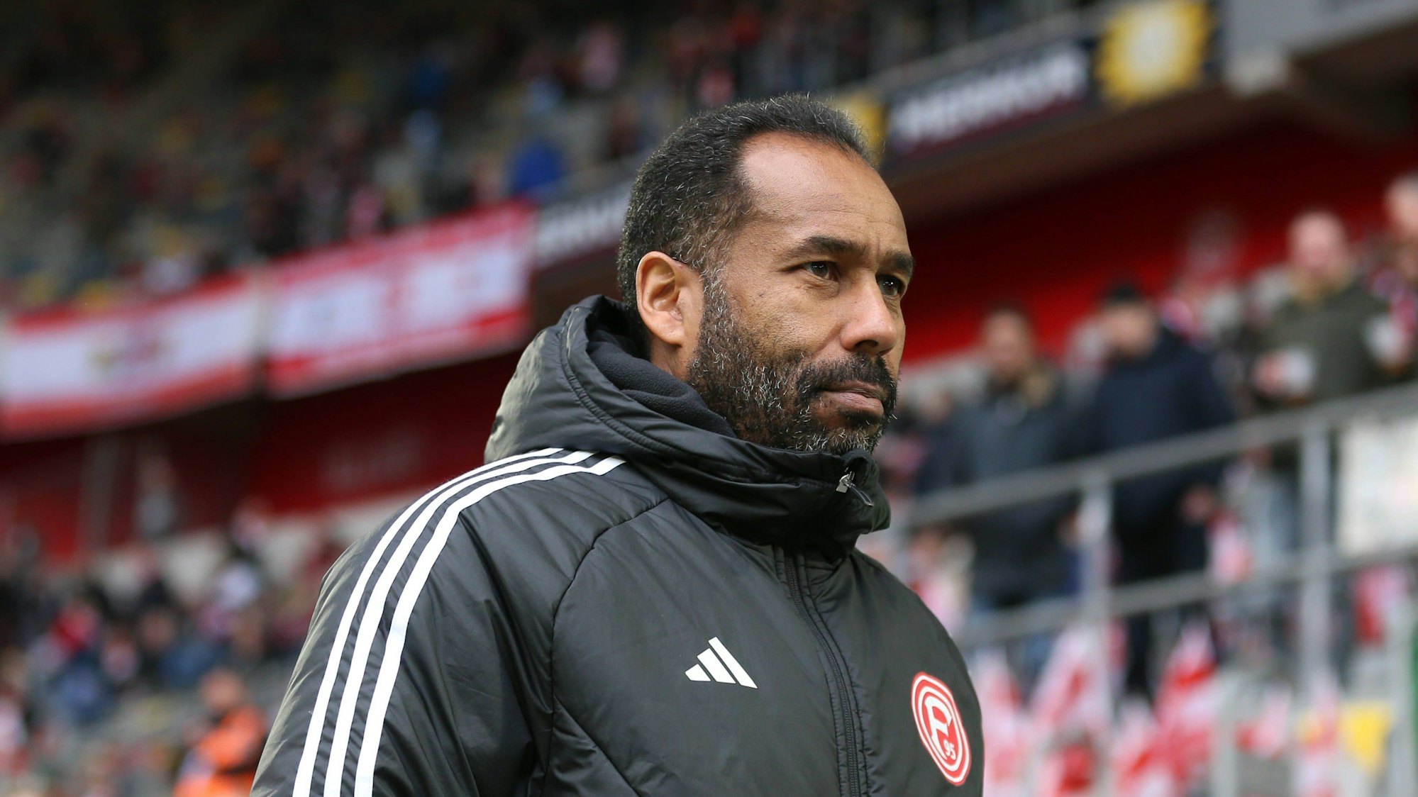 Fortuna Düsseldorfs Trainer Daniel Thioune steht beim Spiel gegen den FC Hansa Rostock im Stadion.