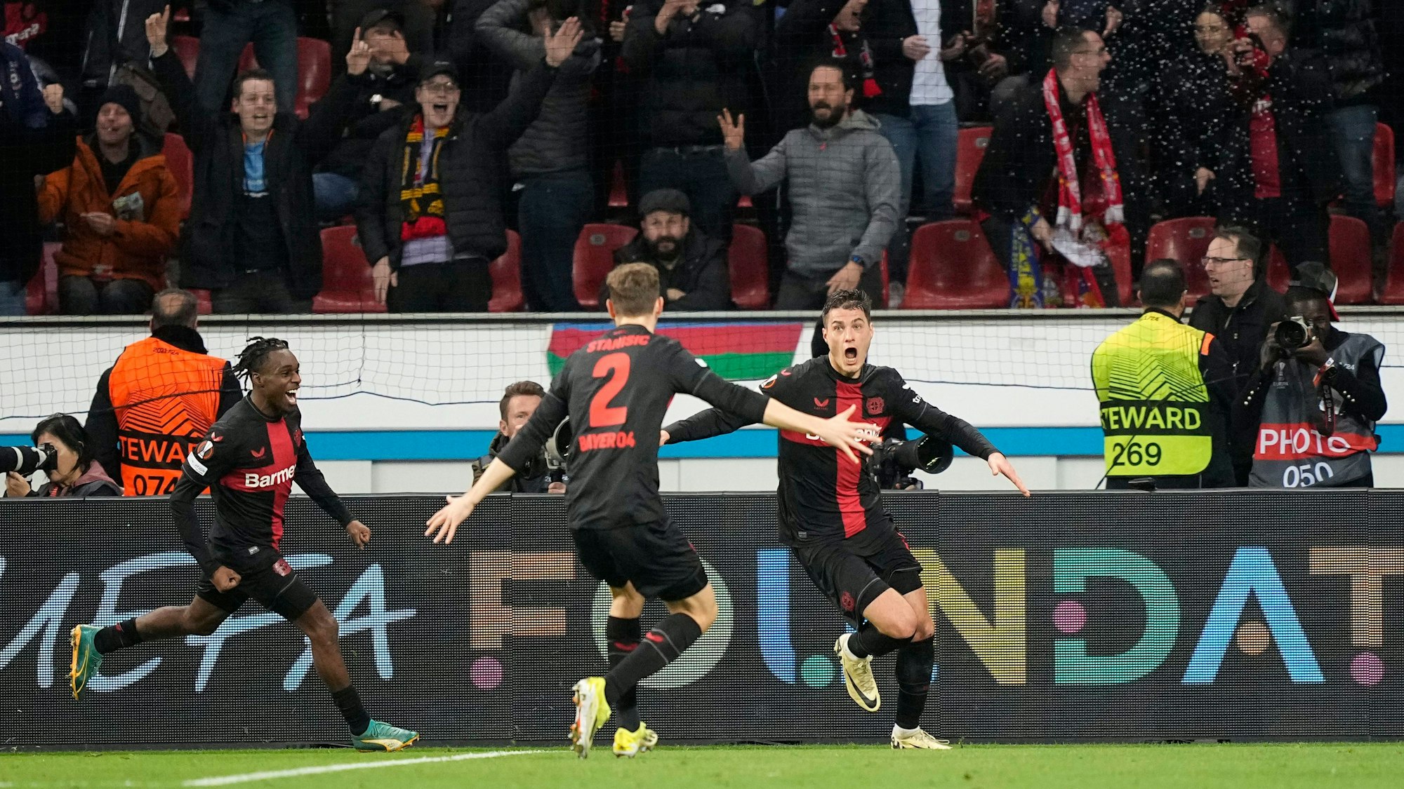 Jeremie Frimpong (l.), Josip Stanisic (M.) und Patrik Schick jubeln nach dem Last-Minute-Treffer gegen Qarabag.