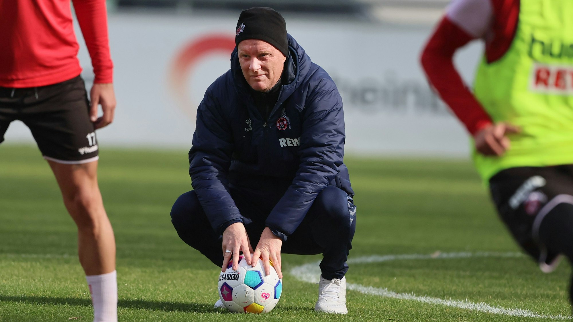 Timo Schultz geht bei einem Training des 1. FC Köln in die Hocke.