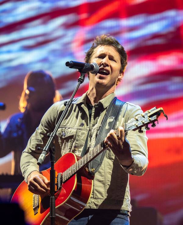 James Blunt steht auf der Bühne und singt.