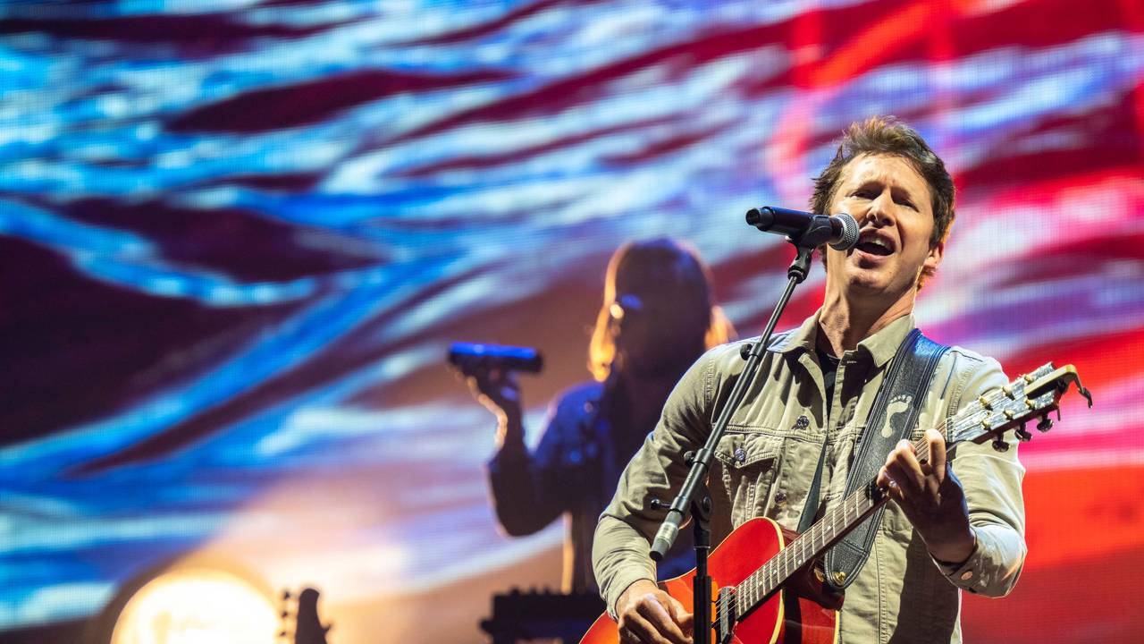 James Blunt steht auf der Bühne und singt.