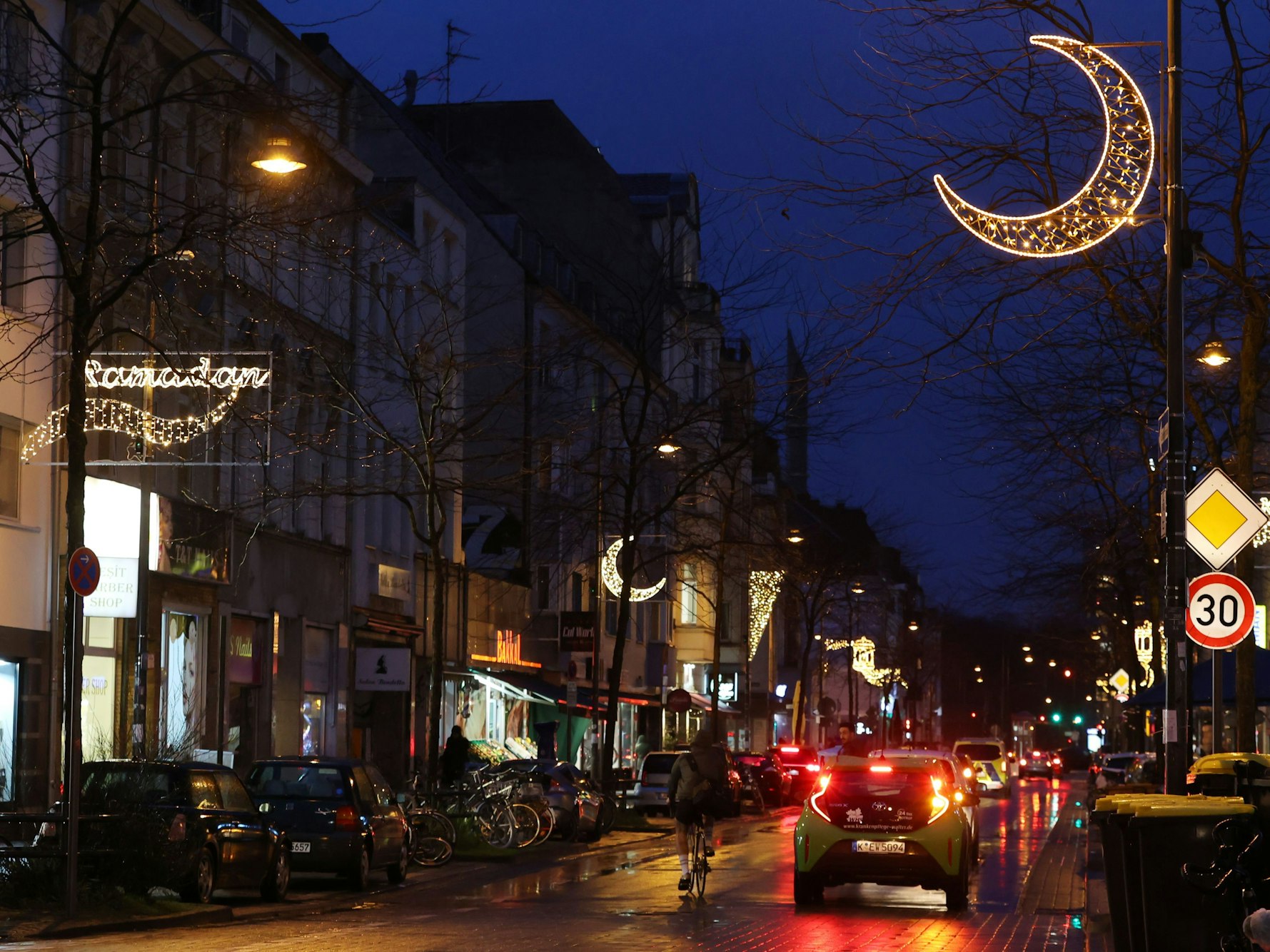 Autos fahren auf der Venloer Straße. Auch die Straßenbeleuchtung ist zu sehen.