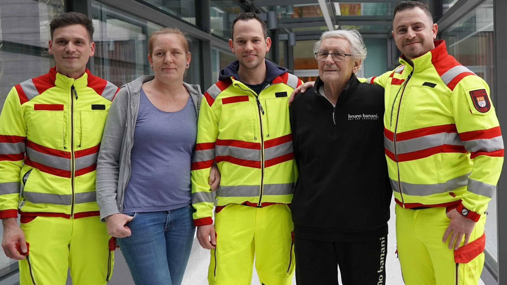 Notfallsanitäter stehen neben einer Frau und einem Mann.