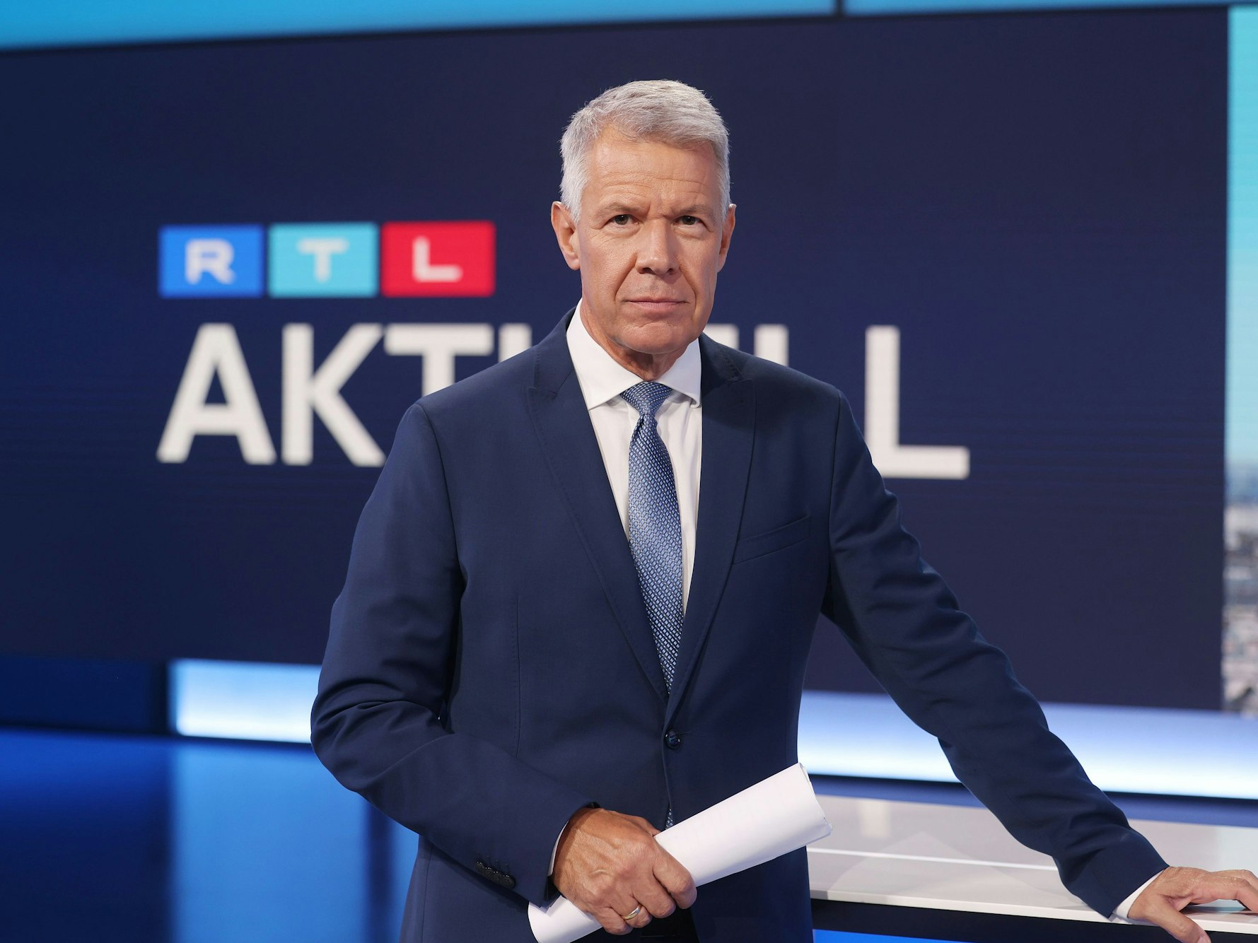RTL-Moderator Peter Kloeppel steht im Studio in Köln. Er trägt einen Anzug und schaut in die Kamera.