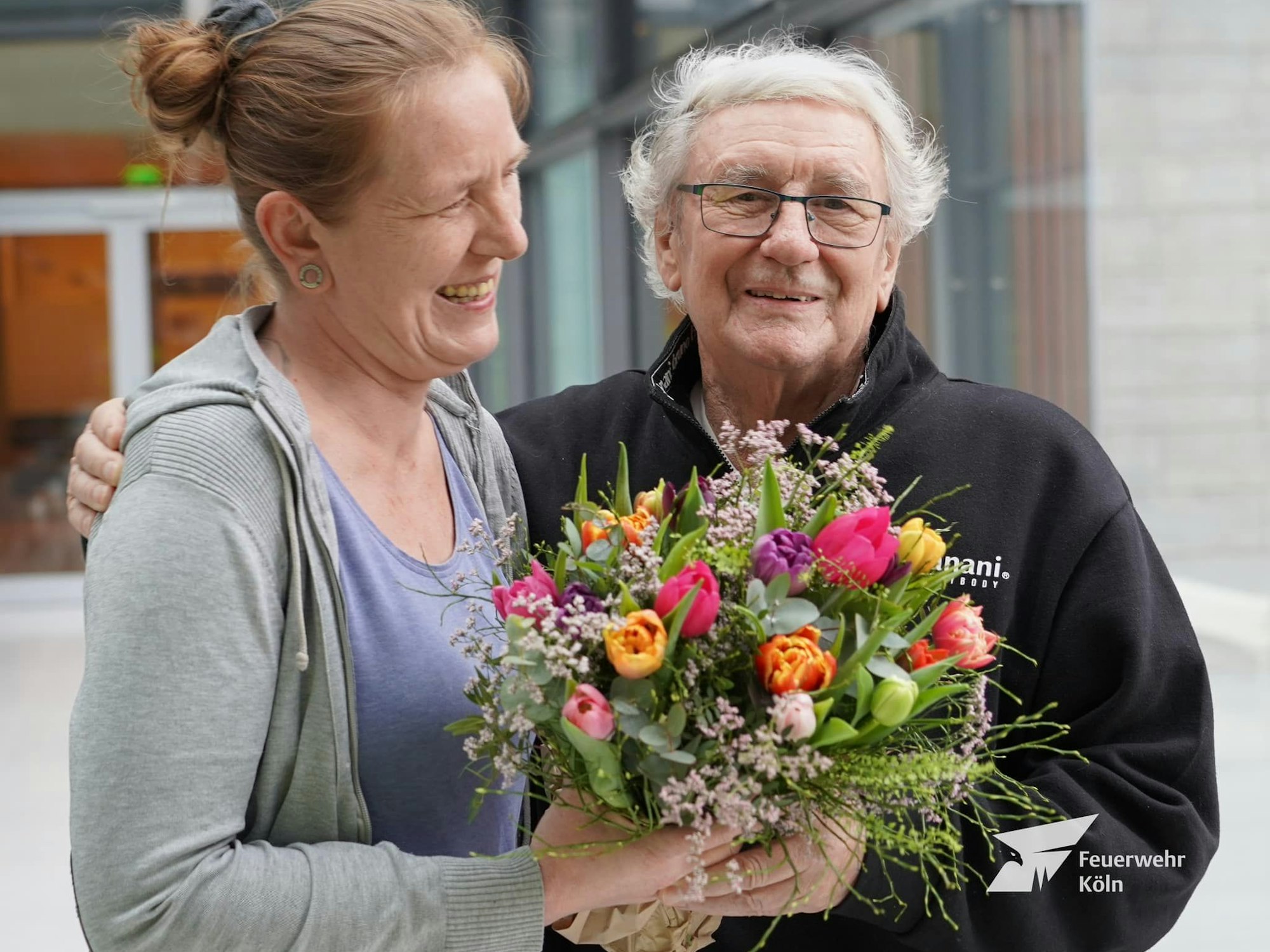 Ein Mann und eine Frau halten einen Blumenstrauß.