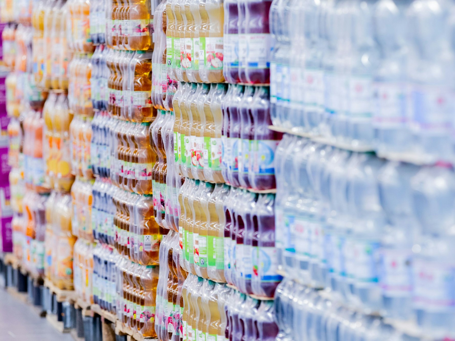 Einweg-Plastikflaschen stehen in einem Supermarkt auf Paletten. Die Supermärkte und Discounter in Deutschland bieten nach Ansicht der Deutschen Umwelthilfe weiterhin zu wenig Waren unverpackt oder in Mehrwegverpackungen an.