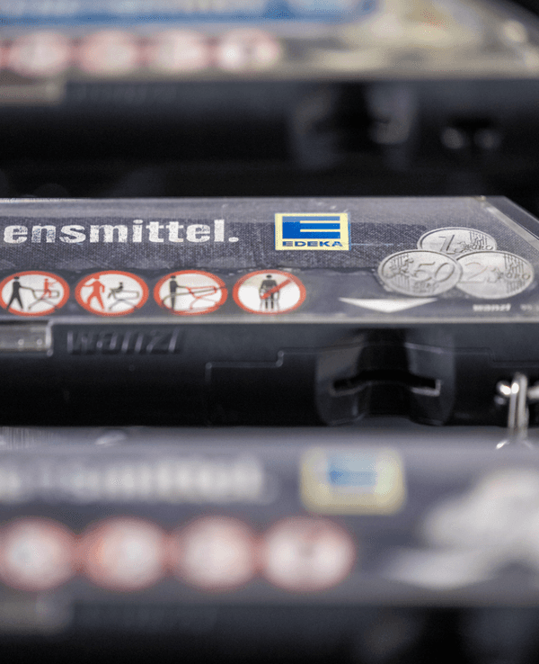 Einkaufswagen stehen vor einer Edeka-Filiale.