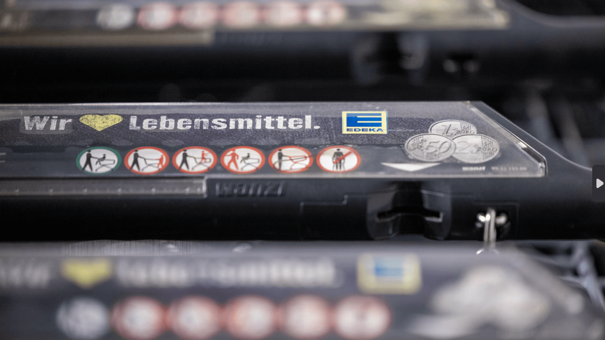 Einkaufswagen stehen vor einer Edeka-Filiale.