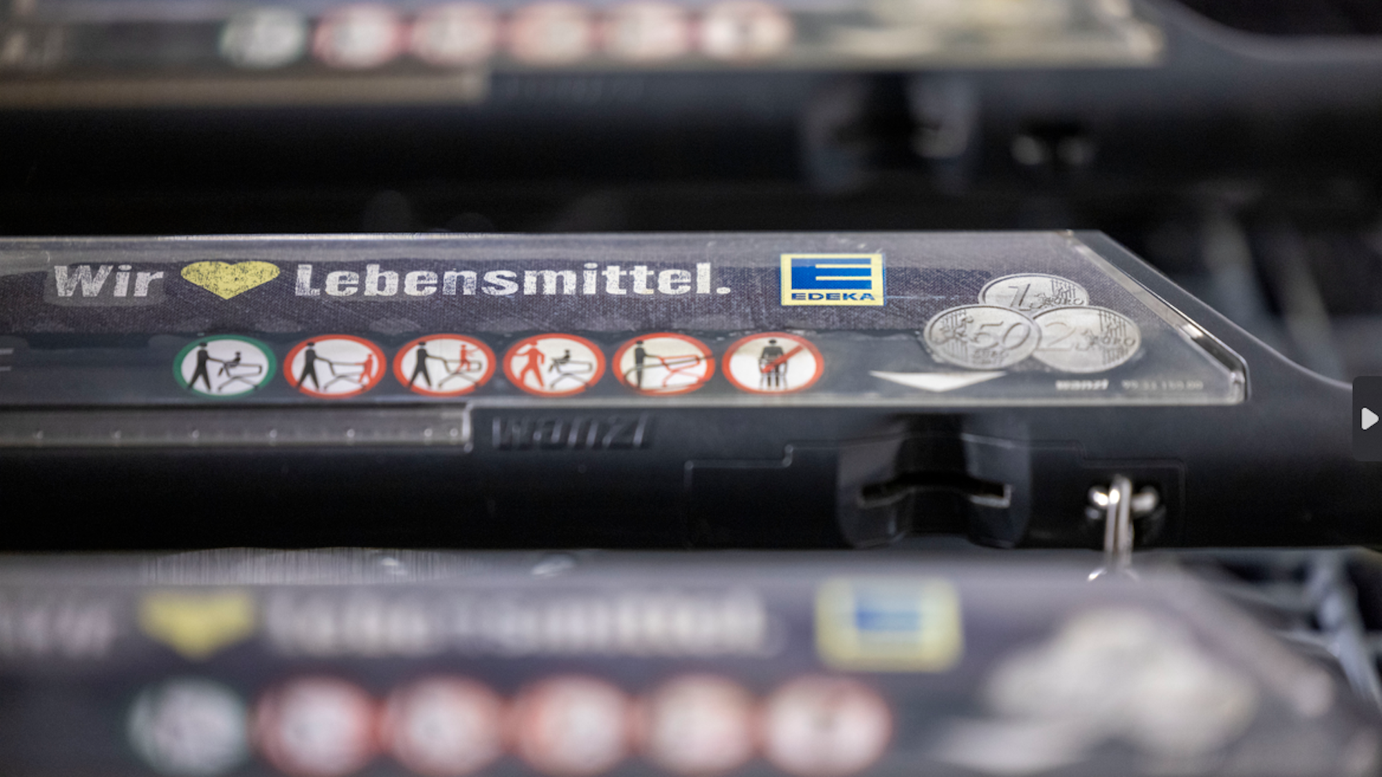 Einkaufswagen stehen vor einer Edeka-Filiale.