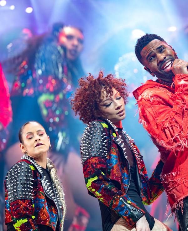 Sänger Jason Derulo mit Tänzerinnen auf einer Bühne.