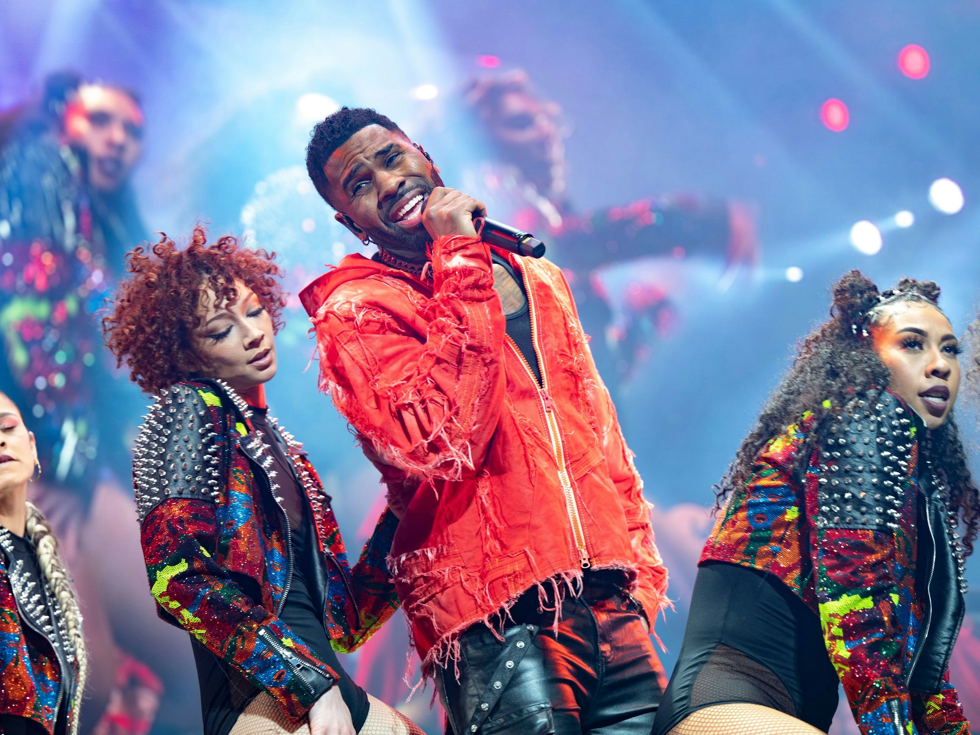 Sänger Jason Derulo mit Tänzerinnen auf einer Bühne.