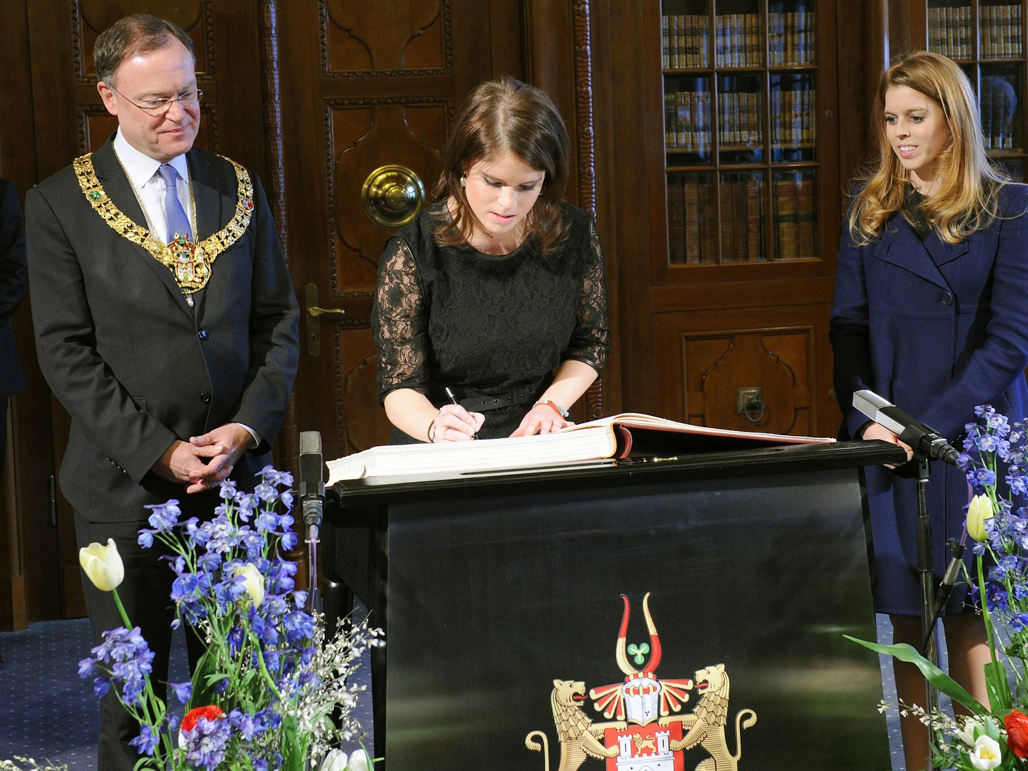 Prinzessinnen Eugenie trägt sich am 18. Januar 2013 in das Gästebuch der Stadt Hannover ein. An ihrer Seite: ihre Schwester, Prinzessin Beatrice (r.) und der damalige Oberbürgermeister Stephan Weil (SPD).
