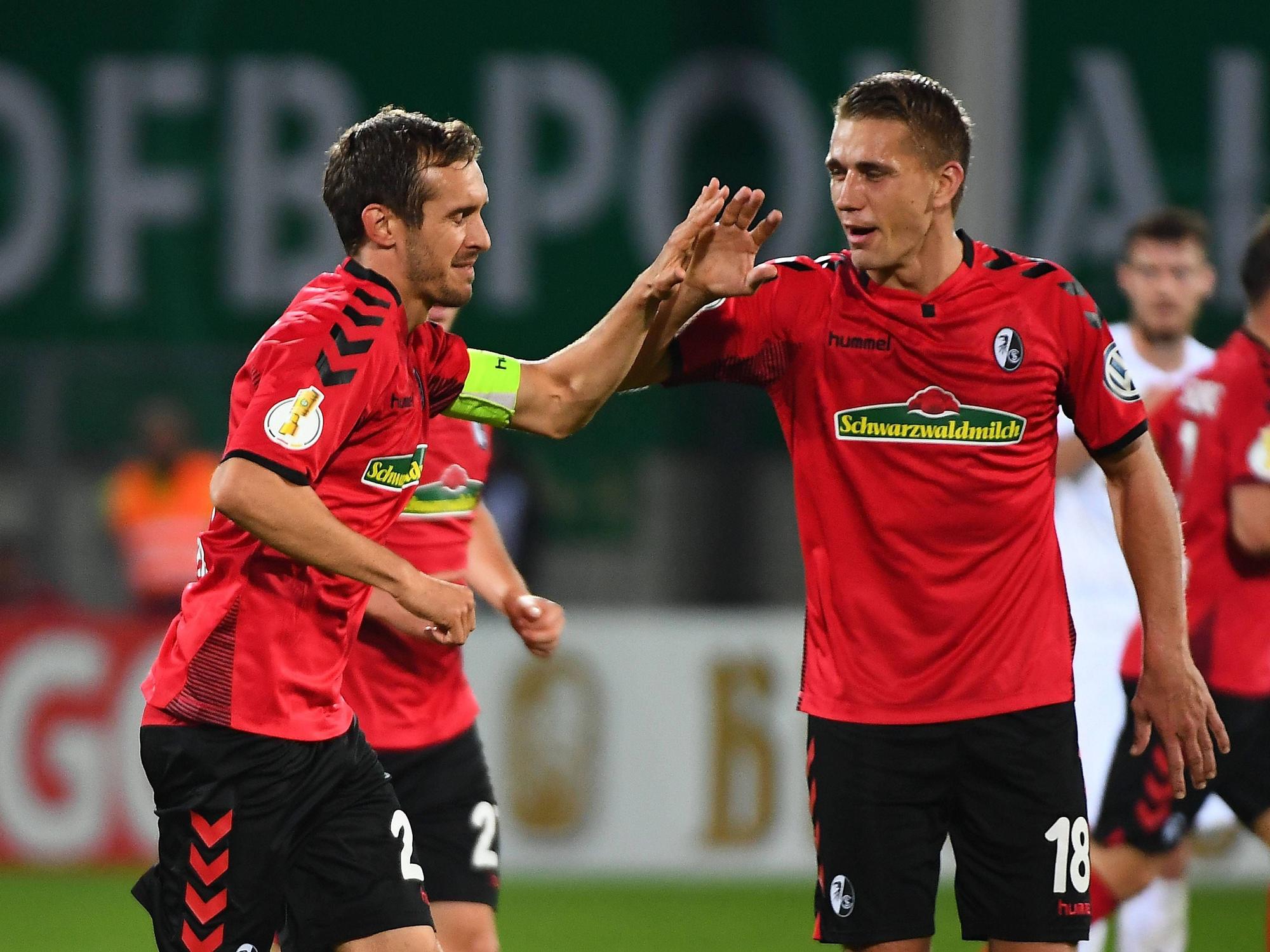 Nils Petersen und Julian Schuster klatschen ab.