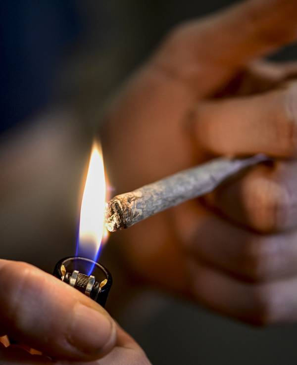 Eine Person zündet sich einen Joint an.