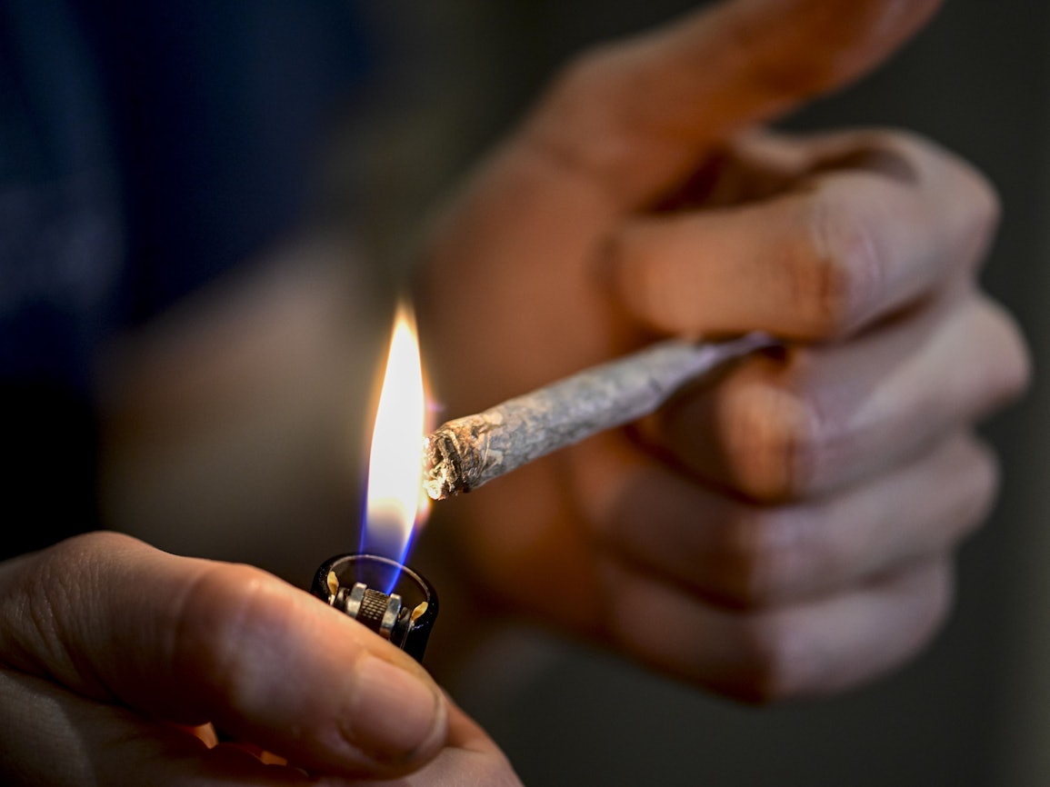 Eine Person zündet sich einen Joint an.