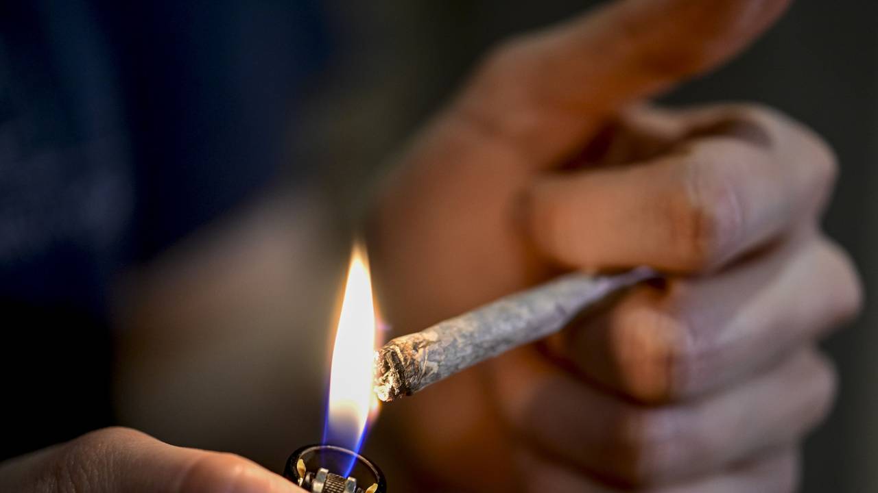 Eine Person zündet sich einen Joint an.