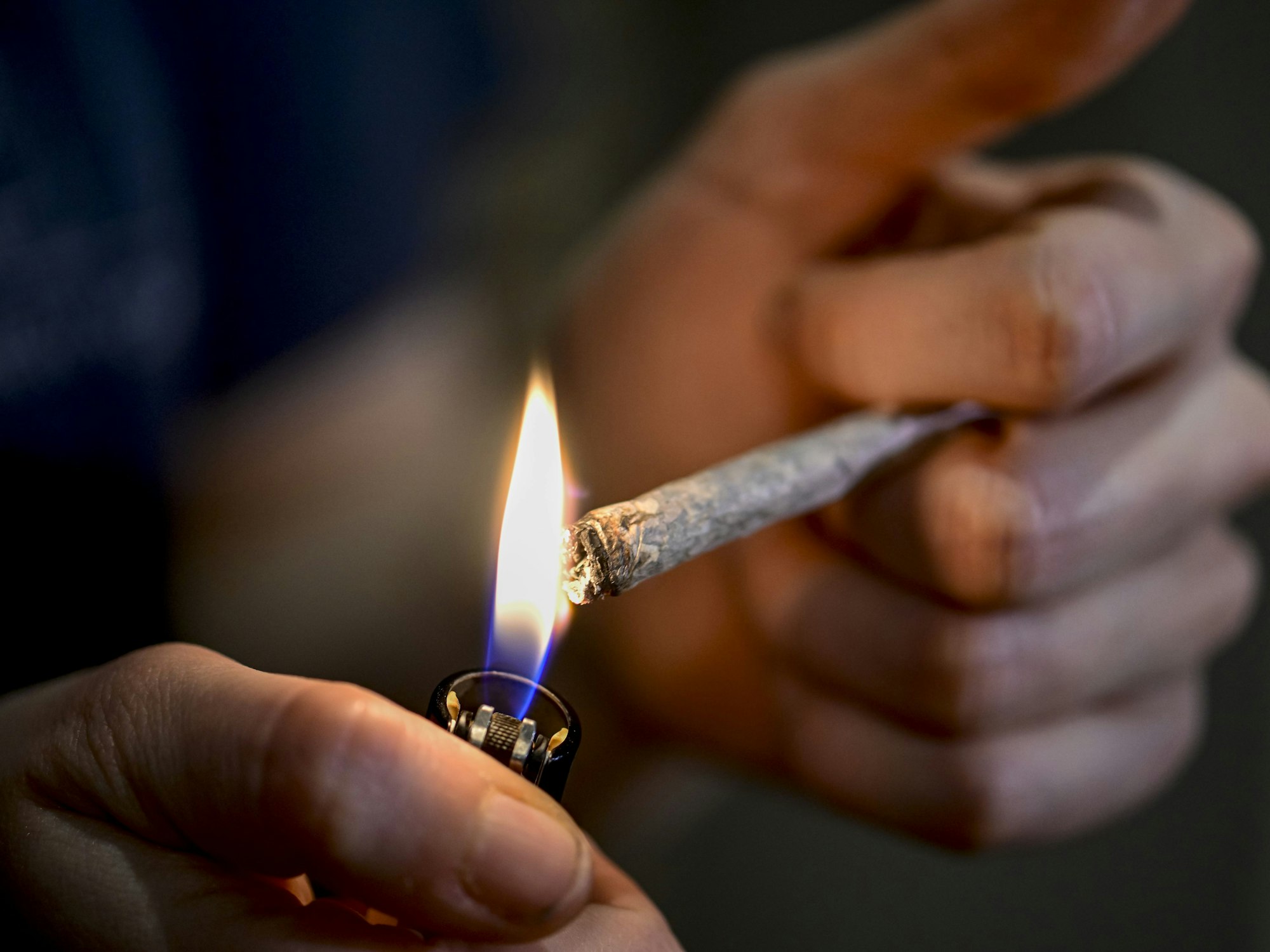 Eine Person zündet sich einen Joint an.