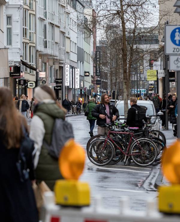 Menschen sind auf der Ehrenstraße unterwegs. Ein Schild zeigt an, dass es sich um eine Fußgängerzone handelt.