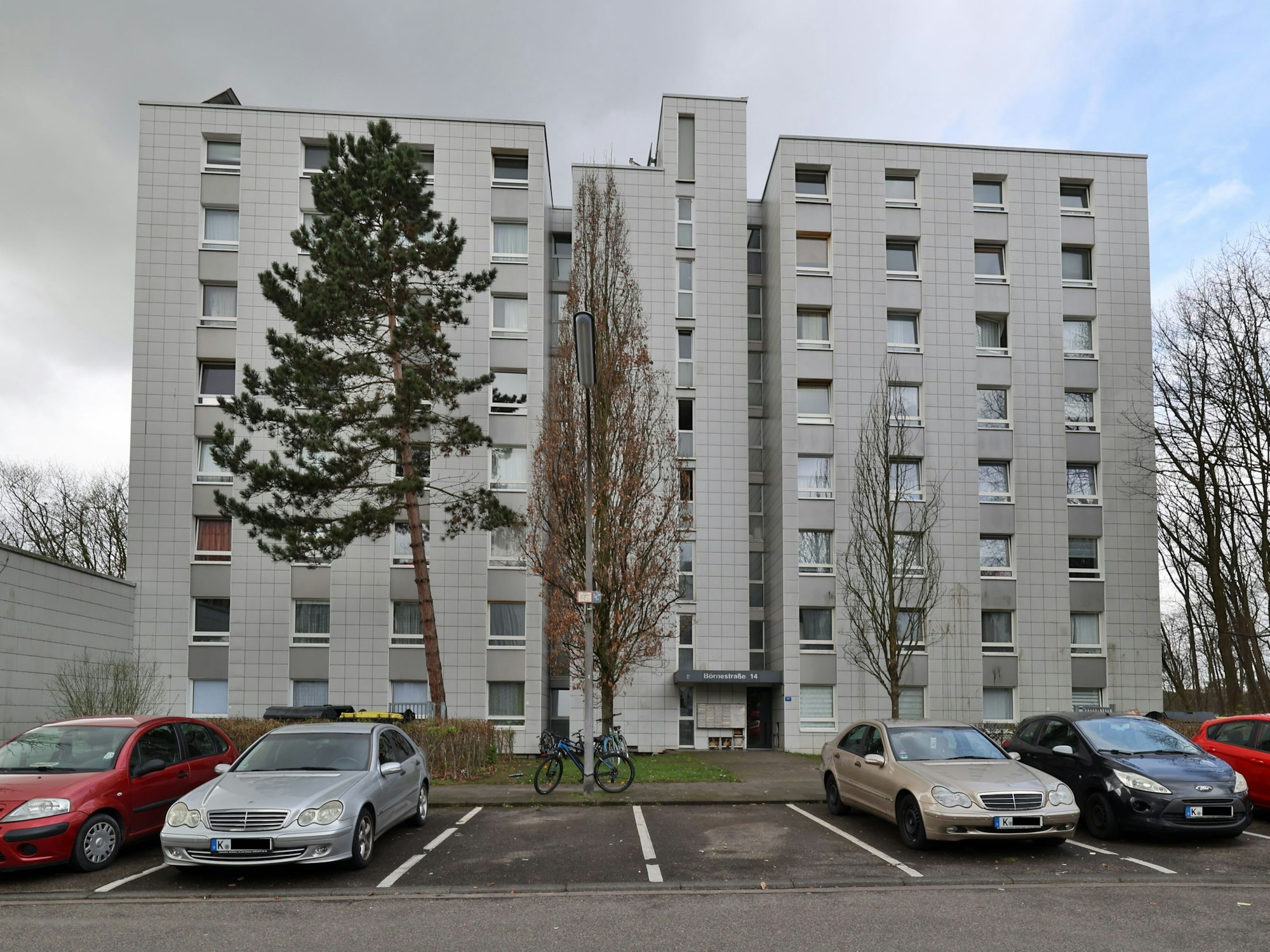 Blick auf ein Wohnhaus mit Parkplatz.