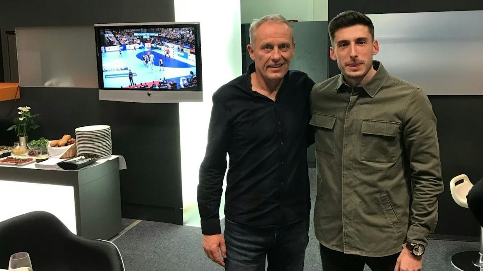 Christian Streich und Gjorgji Antoski in einem Aufenthaltsraum, sie halten sich im Arm.