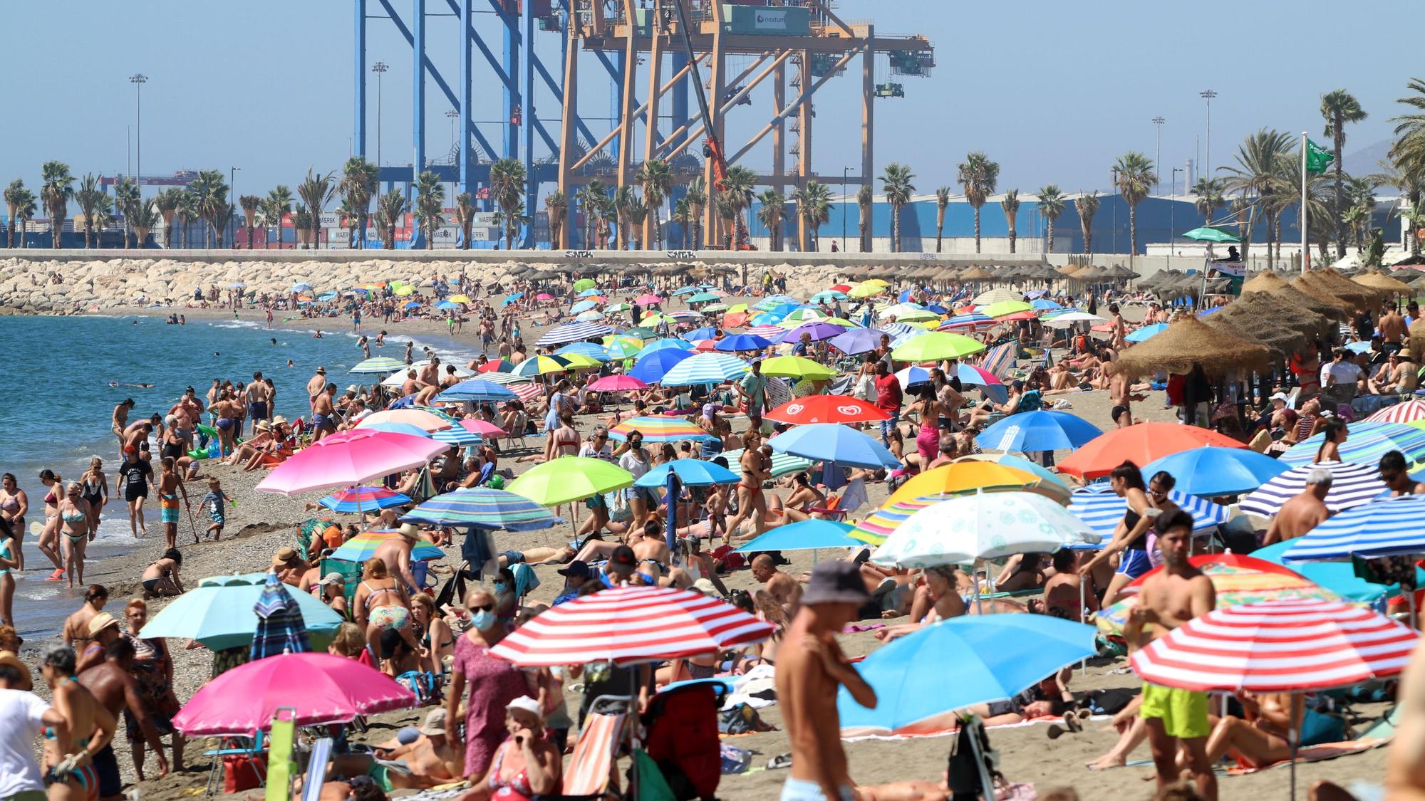 Badegäste und Touristen genießen einen Tag am Strand von La Malagueta.