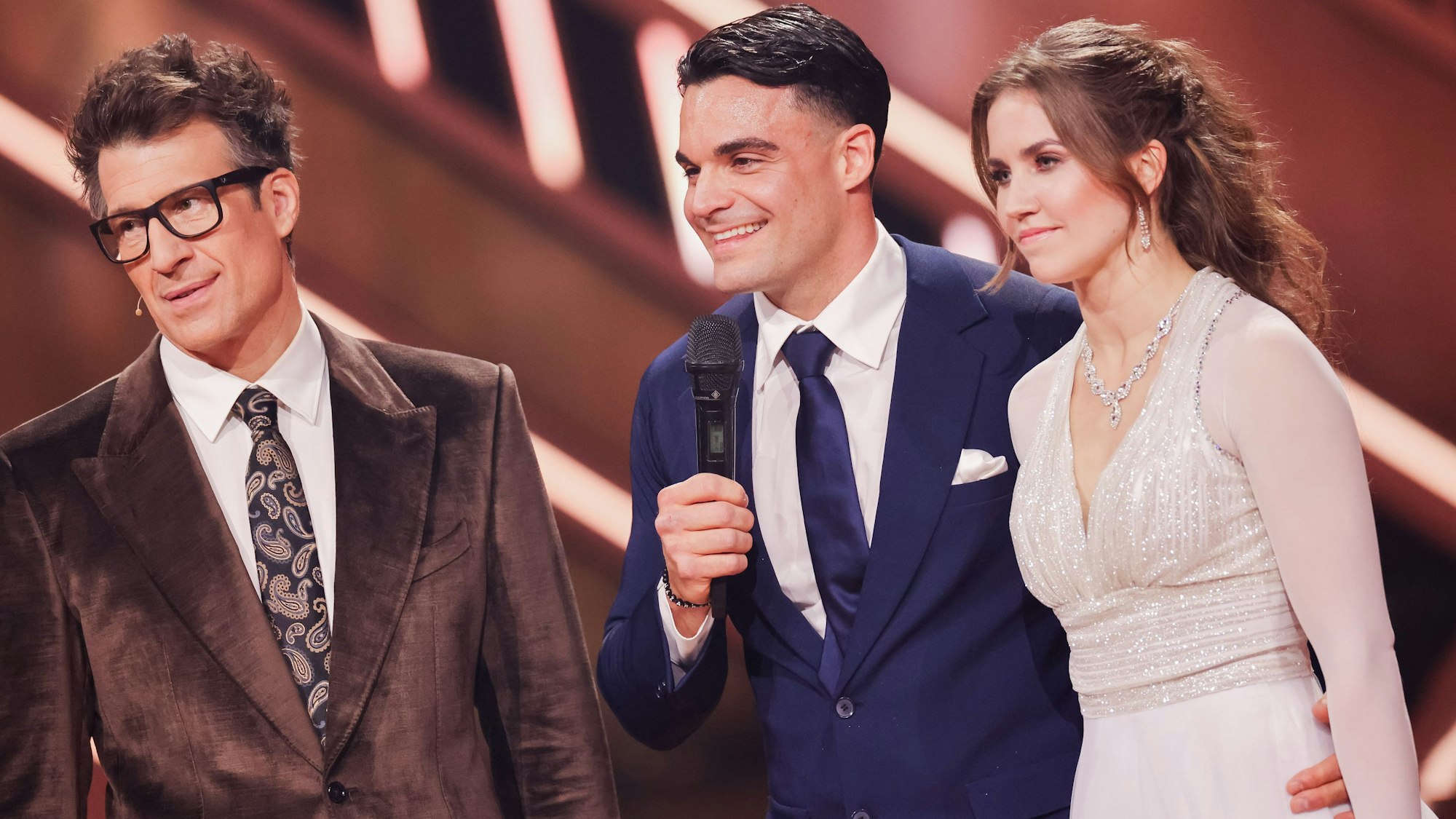 Daniel Hartwich (l-r), Moderator, Stefano Zarrella und Mariia Maksina.