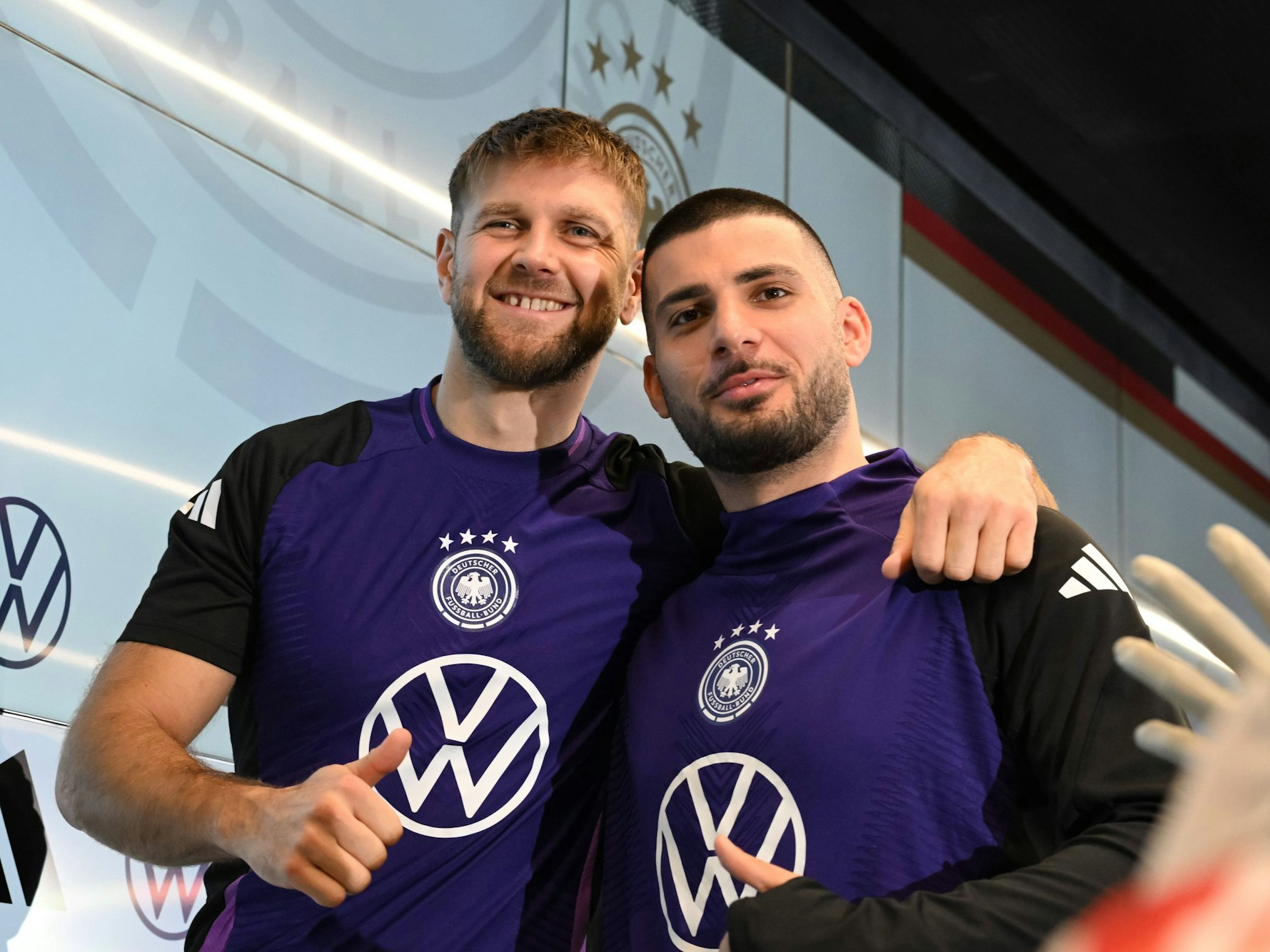 Niclas Füllkrug und Deniz Undav bei der Pressekonferenz posieren für ein Foto.