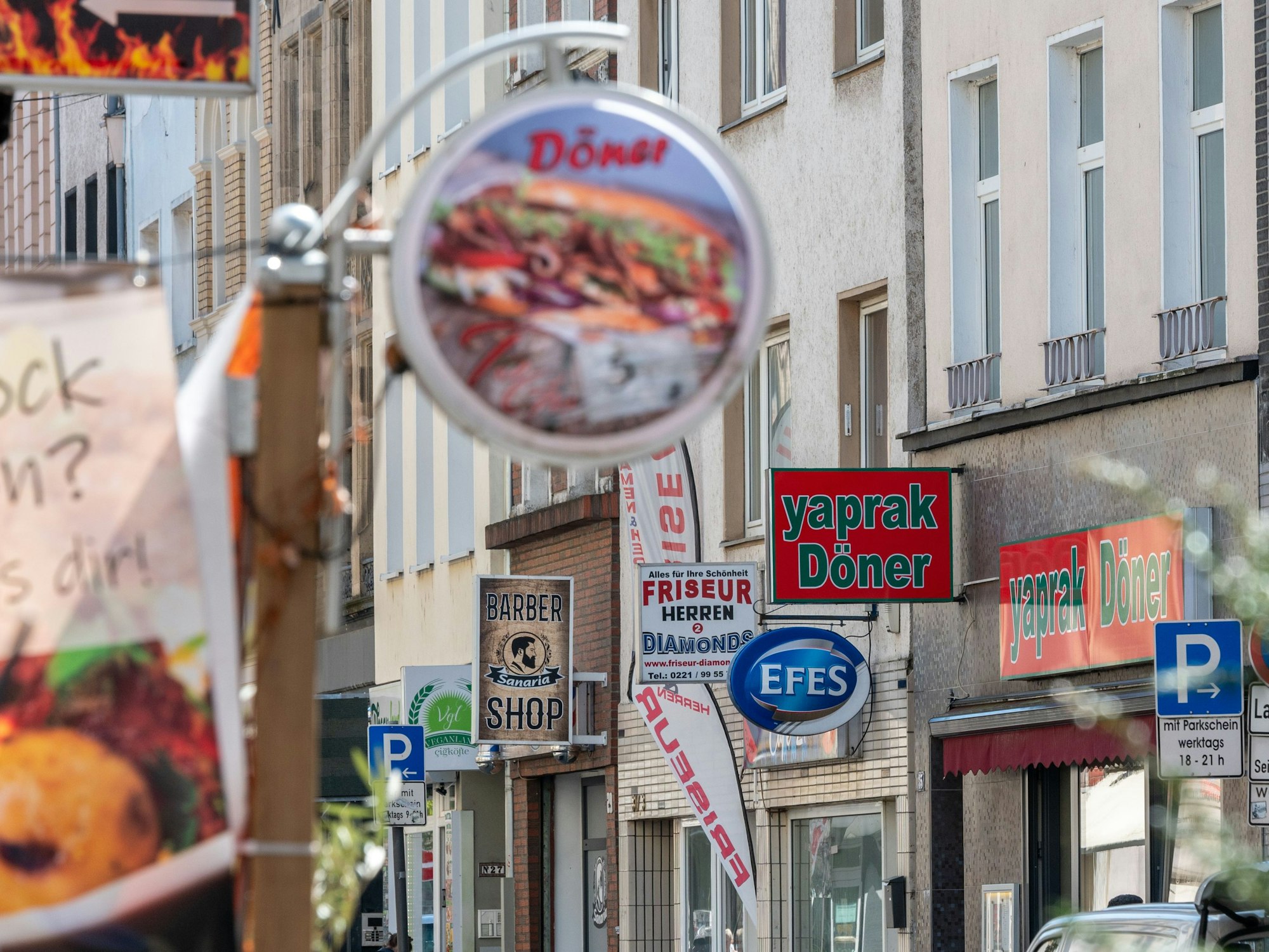 An fast jedem Haus in einer Straße hängt ein Dönerladen-Schild.