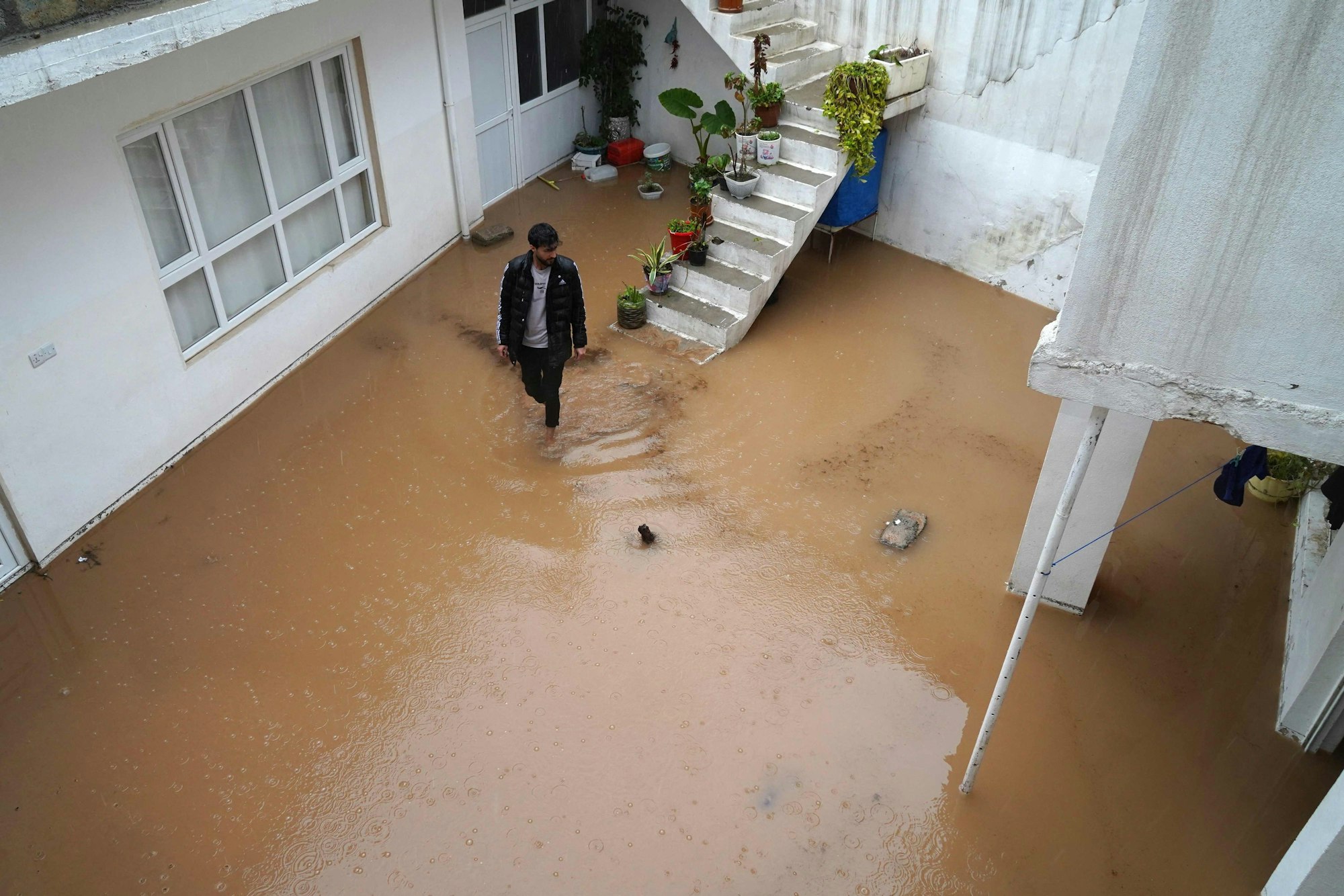 Das Foto zeigt einen überfluteten Hinterhof im irakischen Dohuk Mitte März: Mit fiktiven Wettervorhersagen aus dem Jahr 2050 wollen Kinder gemeinsam mit den UN vor der Klimakrise warnen.