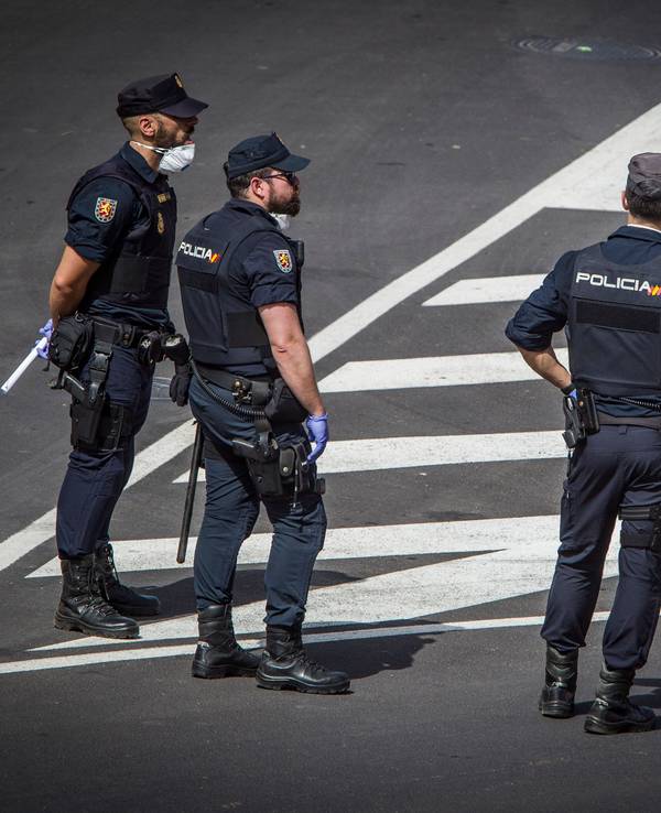 Polizisten mit Atemschutzmasken stehen vor dem Hotel H10 Costa Adeje Palace auf Teneriffa.