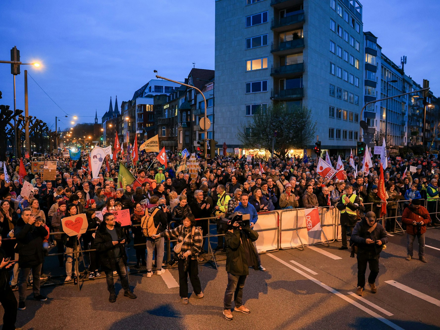Tausende Menschen stehen in einem abgesperrten Bereich am Rheinufer in Köln und demonstrieren.