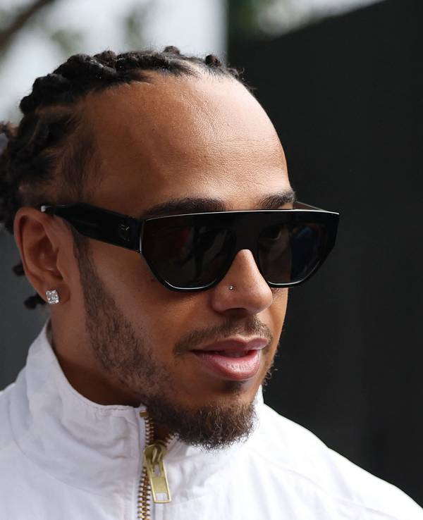 Lewis Hamilton kommt mit Sonnenbrille ins Fahrerlager.