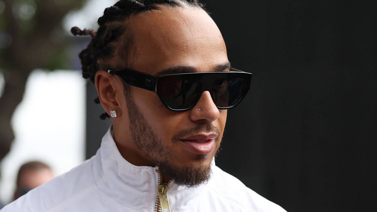 Lewis Hamilton kommt mit Sonnenbrille ins Fahrerlager.