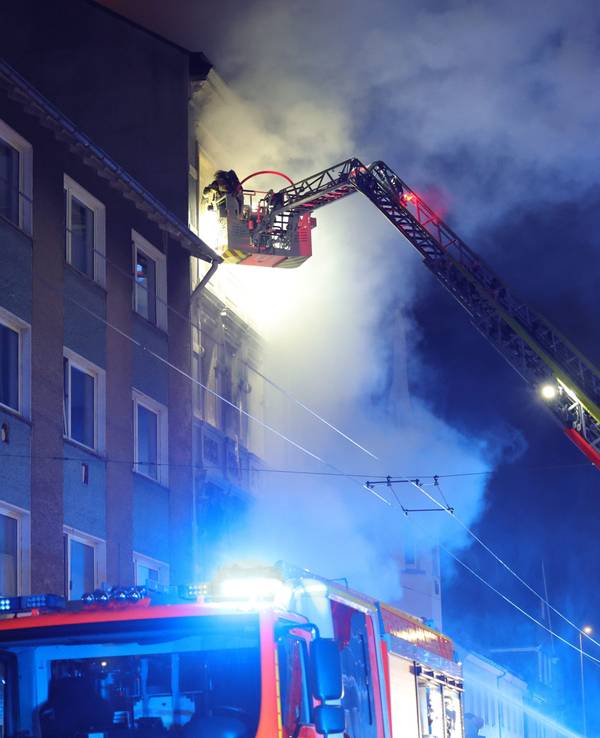 Von einer Drehleiter aus bekämpft ein Feuerwehrmann am 25. März einen Brand in einem Mehrfamilienhaus. Bei dem Wohnungsbrand ist eine Familie getötet worden.