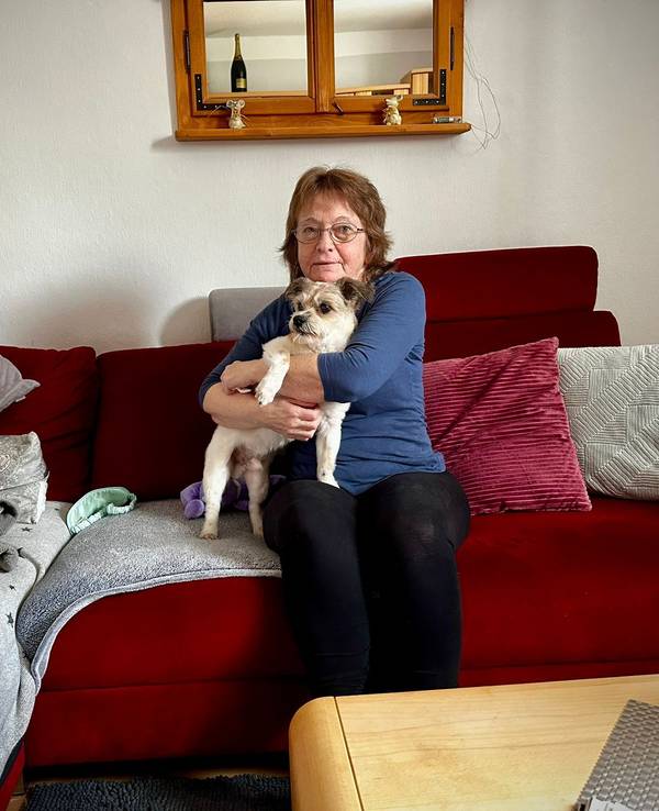 Roswitha Kirsch mit ihrem Hund Arko auf der Couch.