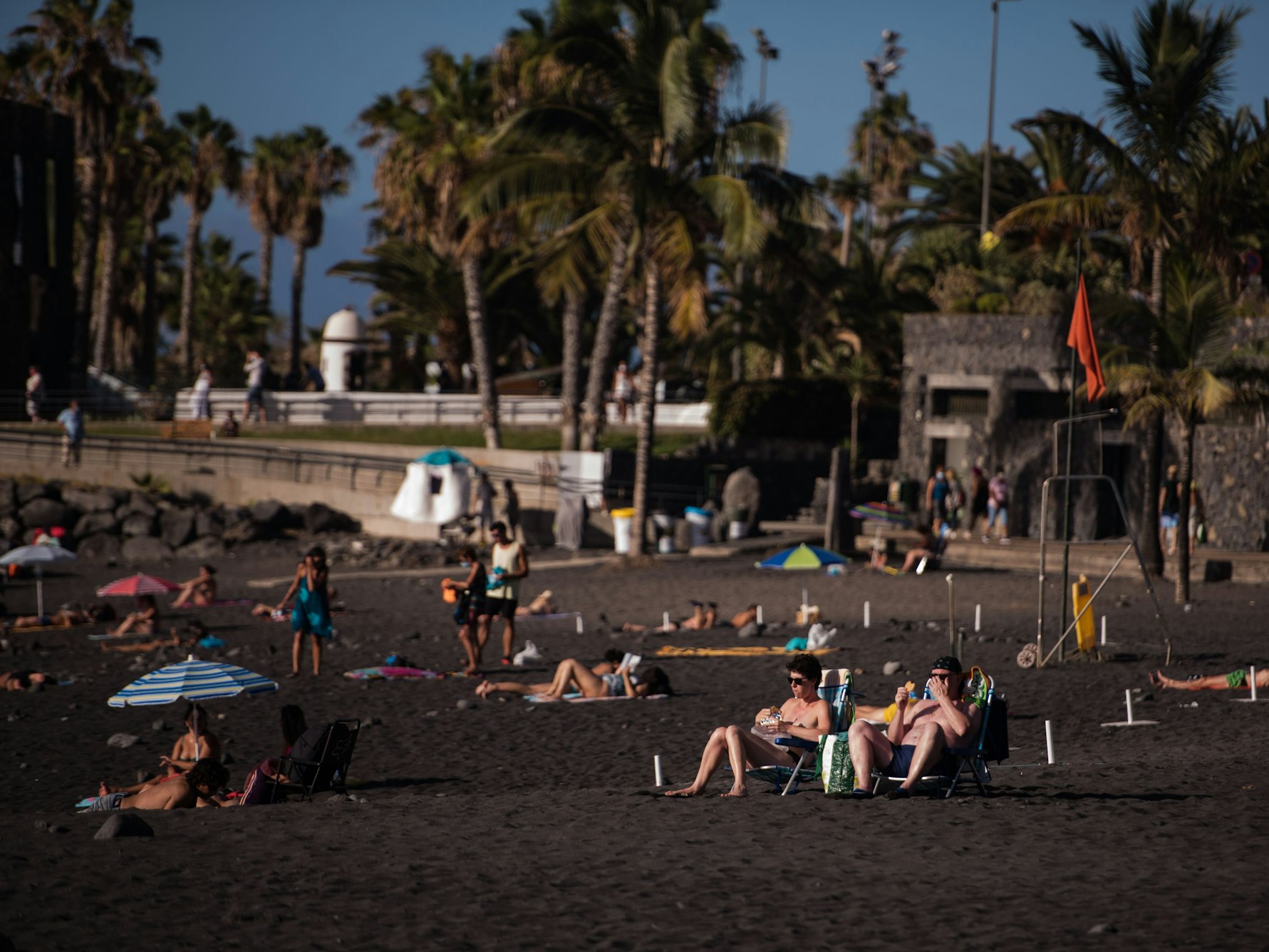 Touristinnen und Touristen sonnen sich am Playa Jardin in Santa Cruz in Teneriffa.