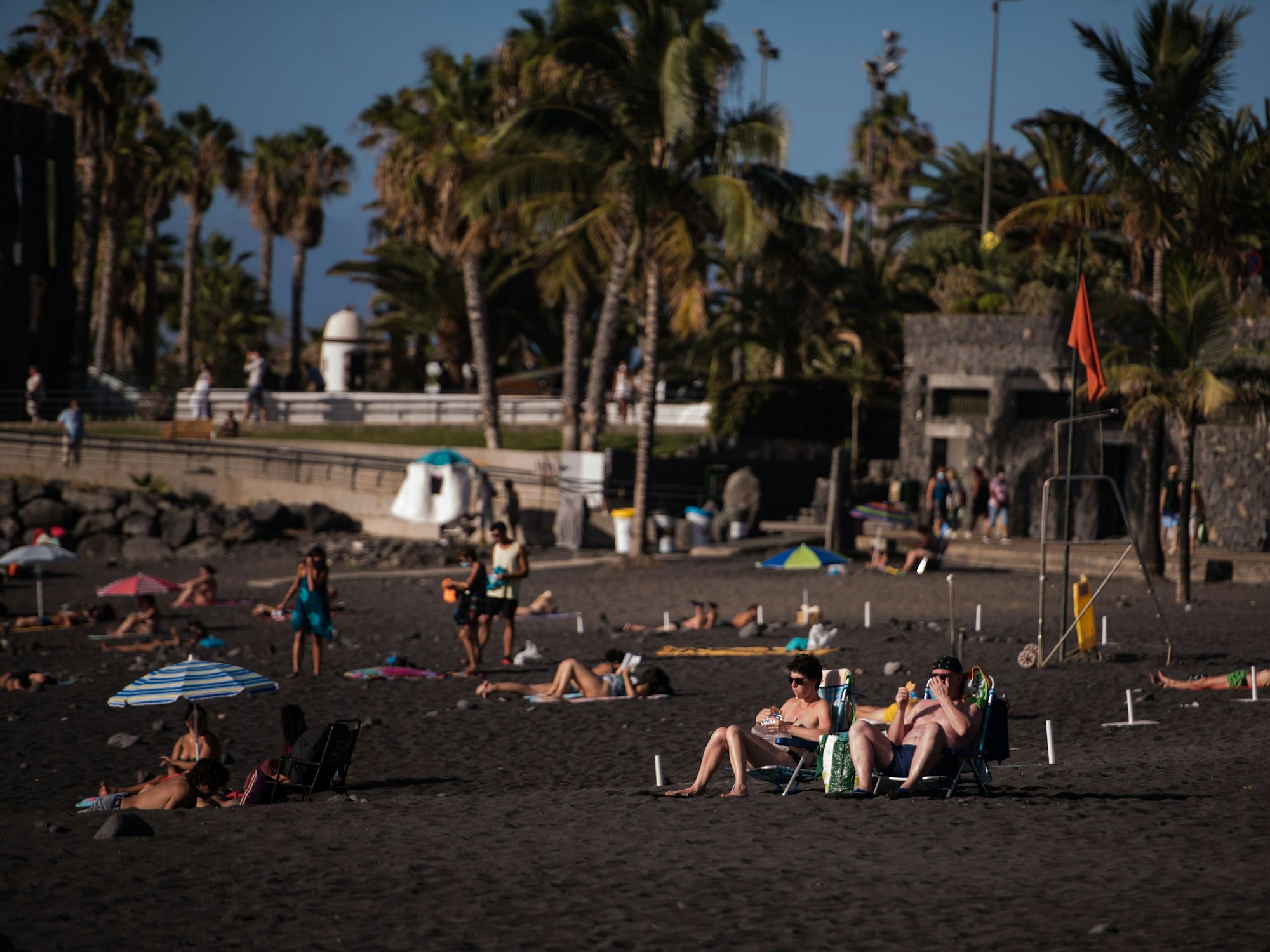Touristinnen und Touristen sonnen sich am Playa Jardin in Santa Cruz in Teneriffa.