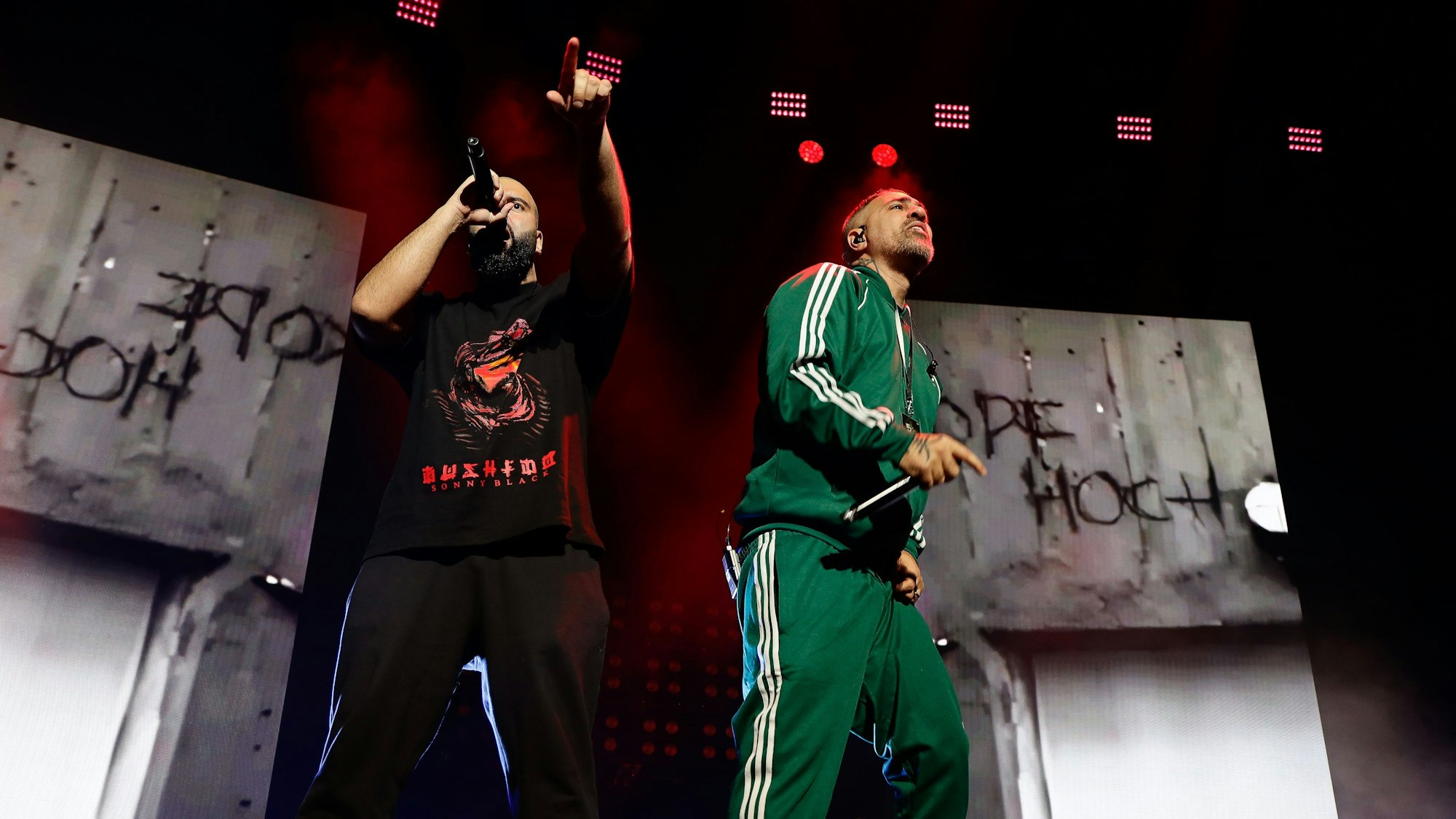 Animus und Bushido stehen auf der Bühne. Aninus hält sich das Mikrofon an den Mund.