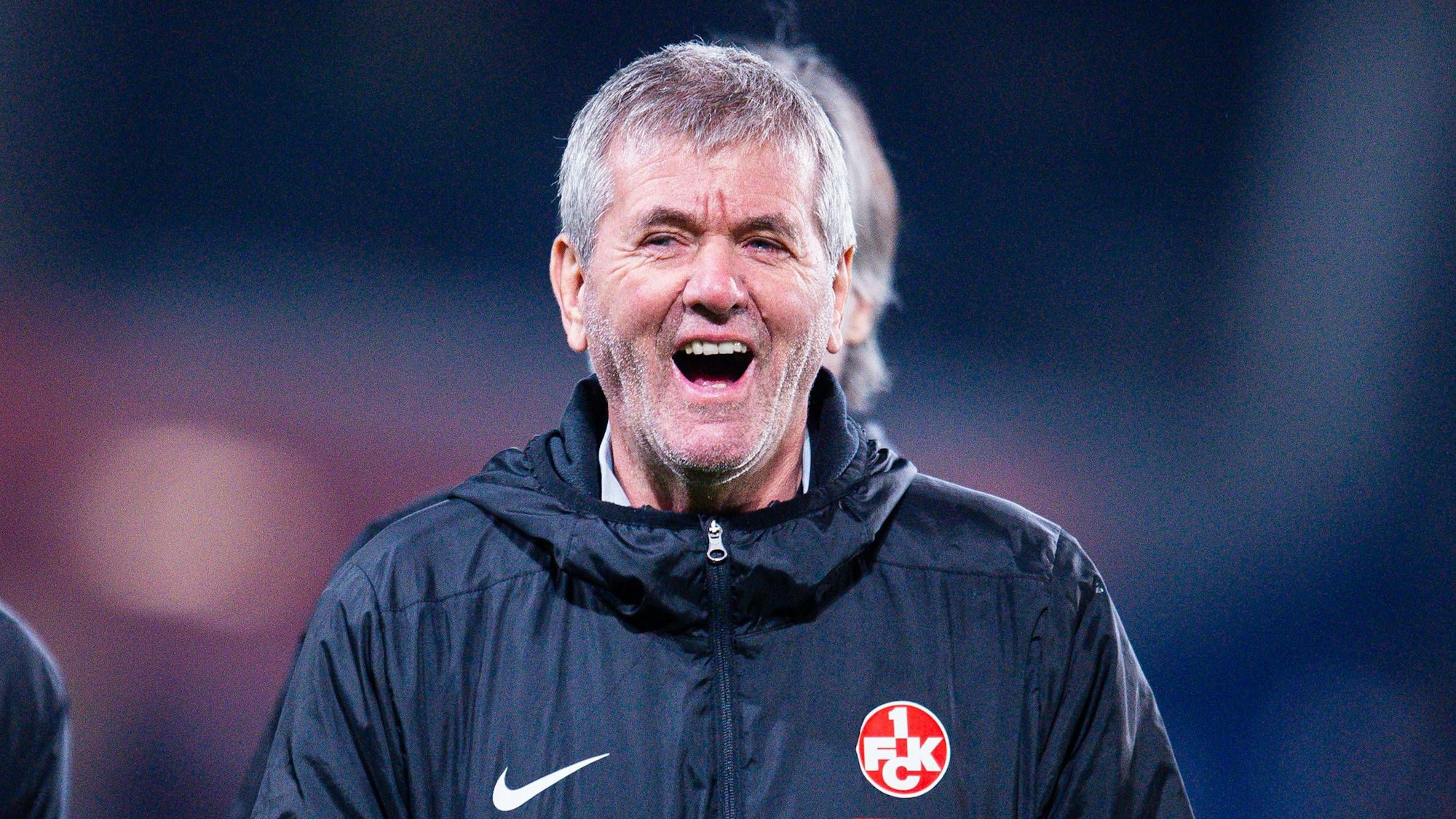 Kaiserslauterns Trainer Friedhelm Funkel steht beim Spiel in hannover lachend auf dem Rasen.